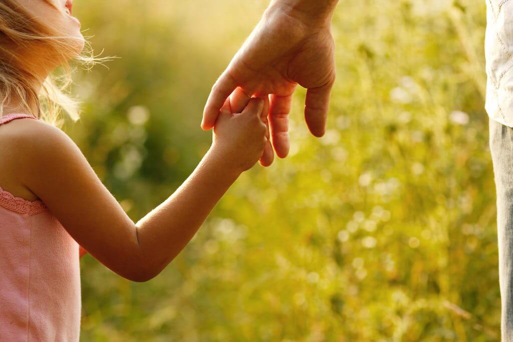 Small child holding parent's hand
