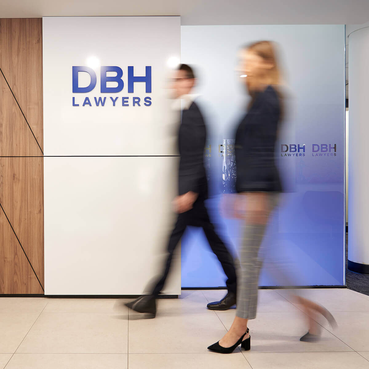 Employees walking past DBH Logo